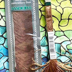 May include: Brown embroidery floss from DMC and Madeira. The DMC floss is labeled S434 and the Madeira floss is labeled 2003 26. The floss is 100% cotton and 11 yards (10 meters) long.