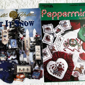 May include: Two cross-stitch patterns, one titled "Let It Snow" with a winter scene and the other titled "Peppermints" with a red and white peppermint design.