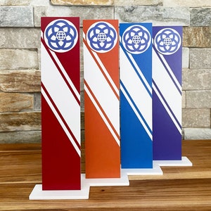 May include: Four decorative, vertical, striped signs with a white background and a blue, red, orange, and purple stripe. Each sign features a blue and white logo of a circle with a globe inside.