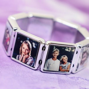 May include: A silver-toned link bracelet featuring multiple square frames, each containing a distinct color photograph of a person. The bracelet is constructed from connected metallic segments that hold the individual portrait images in place.