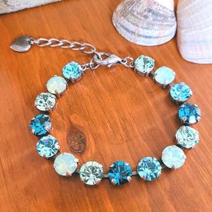 May include: A white ceramic mug with a black handle and the text "But First, Coffee" in a black, bold font. The mug is sitting on a white surface. The mug is approximately 4 inches tall.