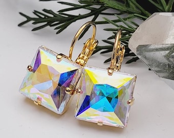 May include: A pair of gold earrings with iridescent square-shaped crystals. The earrings have a lever back closure.