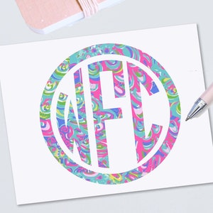 May include: A white monogram with the letters "WFC" in a circle. The circle is filled with a pink, blue, green, and yellow swirling pattern.