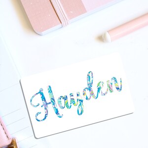 May include: White sticker with the name "Hayden" written in blue cursive script. The letters are filled with a colorful, abstract pattern.