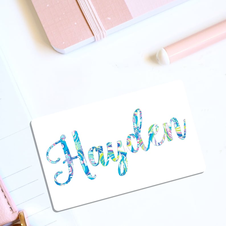 May include: White sticker with the name "Hayden" written in blue cursive script. The letters are filled with a colorful, abstract pattern.