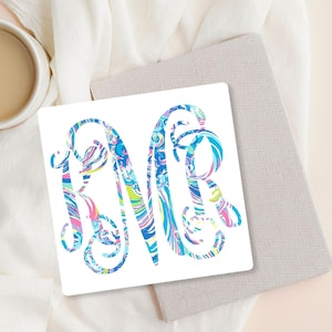 May include: A white sticker with a monogram of the letters "R" and "R" in a blue, green, pink, and purple swirl pattern.