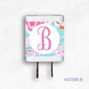 May include: A white electrical outlet adapter with a colorful patterned sticker featuring a pink letter "B" in a white circle. The pattern includes pink, blue, green, and orange colors. The text "PATTERN B" is printed below the adapter.