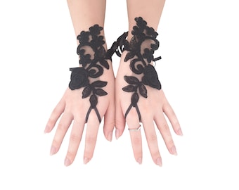May include: A pair of black lace fingerless gloves with floral designs. The gloves have a delicate, feminine look and are perfect for a special occasion.