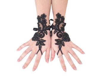 May include: Black lace fingerless gloves with floral and sequin detailing. The gloves have a wrist tie fastening and a delicate design. Ideal for special events or adding a touch of elegance to any outfit.