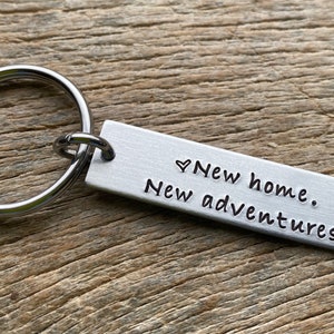 May include: Silver keychain with a rectangular tag that reads "♥ New home. New adventures."