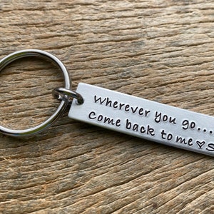 May include: Silver keychain with a rectangular tag that reads "Wherever you go... come back to me ♥ S".