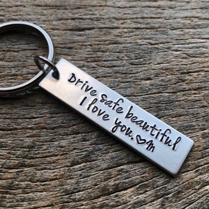 May include: Silver keychain with a rectangular tag that reads "Drive safe beautiful I love you. ♥ M".