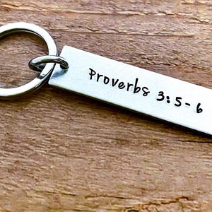 May include: A silver keychain with a rectangular tag that reads "Proverbs 3:5-6".