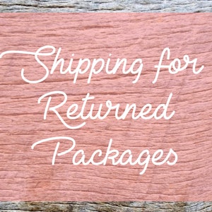 May include: A pink wooden sign with white text that reads "Shipping for Returned Packages".