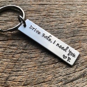 May include: Silver keychain with the text "Drive safe. I need you" and a heart symbol.