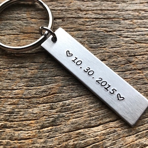 May include: Silver keychain with a rectangular tag engraved with a heart and the date 10.30.2015.