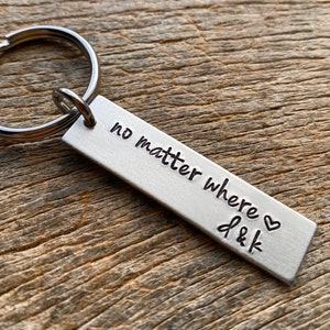 May include: Silver keychain with a rectangular tag that reads "no matter where" and "J & K" with a heart symbol.