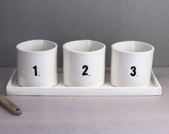 Verkauf. Zweitens. Nummerierte Tassen in einem Tablett. Nummerierte Keramikbecher. 2 1/2" hohe handgefertigte Keramikbecher in handgefertigtem Keramiktablett.