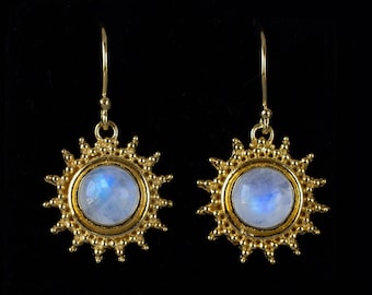 Può includere: Un paio di orecchini d'oro con un centro di pietra di luna e un design a forma di sole.