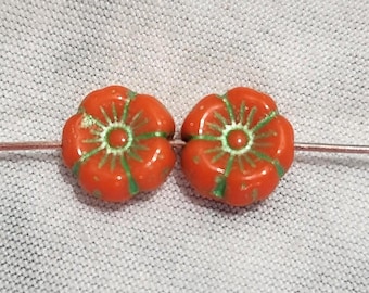 Ocho cuentas de vidrio checo con forma de flor hawaiana de 8 mm en color naranja con detalles en verde metálico.