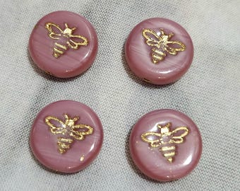 Cuatro cuentas de vidrio checo en forma de moneda de 12 mm en color rosa con detalles dorados.