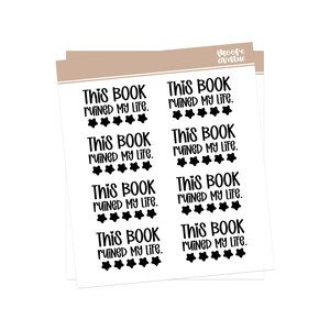 May include: White sticker sheets with the text "This Book Ruined My Life" in black, with black star accents. The stickers are arranged in rows and columns, with the words in a bold, handwritten style.