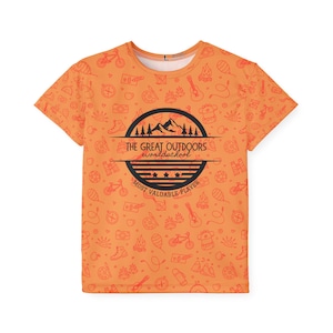 May include: A white ceramic mug with a black handle and the text "But First, Coffee" in a bold, black font. The mug is set against a blurred background. The mug appears to be approximately 10 cm tall.