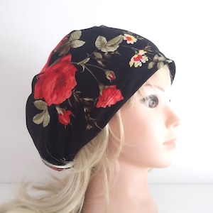 May include: Black beanie with a floral pattern featuring red roses and green leaves.