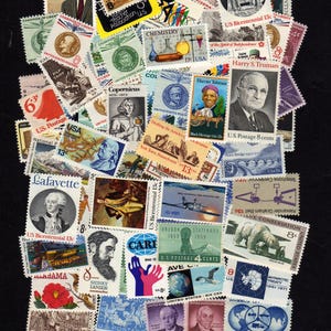 May include: A collection of vintage postage stamps featuring historical figures, scientific illustrations, and commemorative designs. The stamps showcase a variety of colors and themes, including portraits of U.S. presidents, scientific advancements, and historical events. The stamps are of various sizes and denominations.