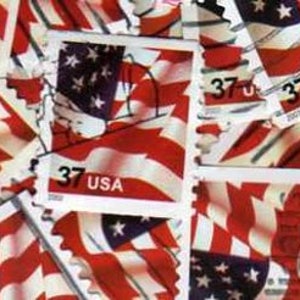 May include: A close-up of a pile of US postage stamps featuring the American flag. The stamps are all 37 cents and have the text "USA" printed on them.