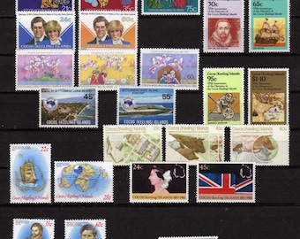 Op de afbeelding: Een verzameling postzegels van de Cocos (Keeling) Eilanden. De postzegels tonen portretten, historische figuren, schepen en landschappen. Verschillende denominaties worden weergegeven, met kleuren als blauw, rood en groen.