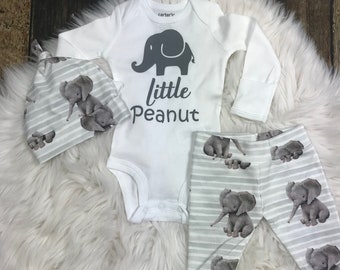 May include: A white baby onesie with a gray elephant and the text "little peanut". A gray and white striped hat with a gray elephant design. Gray and white striped pants with a gray elephant design.