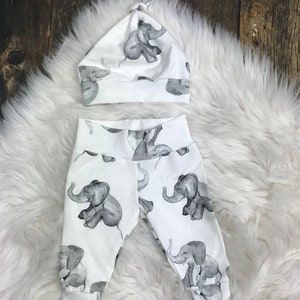 May include: White baby leggings and a hat with a gray elephant print.