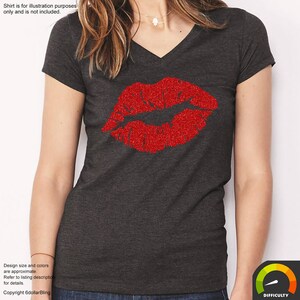 May include: Dark gray v-neck t-shirt featuring a large, glittery red lips design. The shirt's design is for illustration purposes only and is not included. The text on the image says "Design size and colors are approximate. Refer to listing description for details. Copyright 6dollarBling."