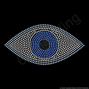May include: A stylized eye design composed of white, blue, and black rhinestones on a black background. The eye shape is outlined with white rhinestones, with a blue iris and a black pupil.