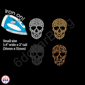 May include: Iron-on skull designs in white, gold, silver, and orange. Each skull is made of small, round rhinestones. The image includes an iron and text that reads "Iron on!" and "Small size 1.4" wide x 2" tall (36mm x 51mm)."