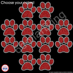 May include: Red glitter paw prints with white rhinestone outlines on a black background. The phrase "Choose your colors!" is at the top. A "Made in USA" emblem is in the lower left corner. The design is by HipKraft & 6dollarBling.