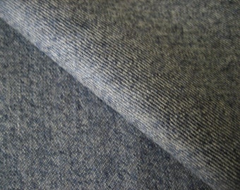May include: Close-up of a blue denim fabric with a diagonal weave pattern.