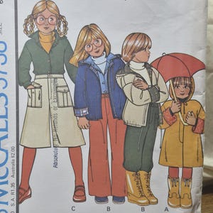 Könnte beinhalten: Eine McCall's 5738 Schnittmusterhülle für Größe 6 mit Illustrationen von Kindern in verschiedenen Mänteln, Jacken, Hemden, Hosen und Culottes. Das Cover zeigt den Text McCall's 5738, Carefree Patterns und Boys' and Girls' Coat or Jacket, Shirt, Pants and Girls' Culottes.