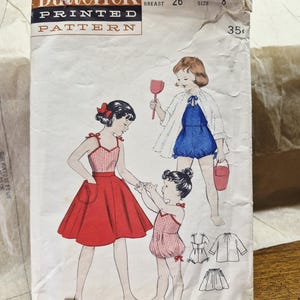 Op de afbeelding: Een Butterick naaipatroon envelop 6964 voor maat 8 met een borstomvang van 66 cm. De voorzijde toont illustraties van kinderen in een rood-wit geblokte top met een rode rok, een blauwe romper met een witte cape en een rood-wit geblokte romper.