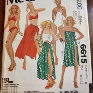 May include: Vintage McCall's sewing pattern envelope featuring illustrations of women's clothing designs. The cover displays various outfits, including a red bikini, a long red skirt, a white swimsuit, and green dresses. The pattern number is 6615, with sizes 8-10-12.