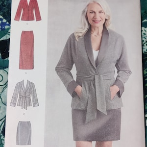 Könnte beinhalten: Eine Frau trägt einen grauen Blazer mit passendem Rock. Der Blazer hat einen Schalkragen, einen Bindegürtel und Taschen. Der Rock ist knielang. Das Bild zeigt auch Illustrationen anderer Rock- und Jackenmodelle.
