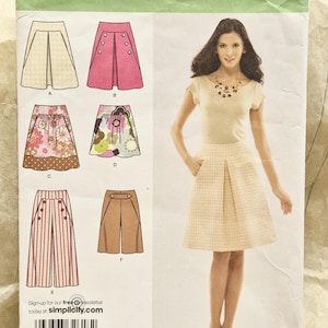 May include: A Simplicity sewing pattern envelope 2656 for sizes D5 4, 6, 8, 10, 12. The front displays illustrations of six skirt and pant variations, including pleated, buttoned, and patterned designs, alongside a photograph of a finished skirt.