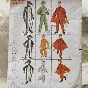 May include: A vintage Butterick 3274 sewing pattern envelope for children's costumes. The front displays illustrations of three costume styles: a black and white bird, a green or orange space suit with a rocket, and a red devil with a cape and tail.