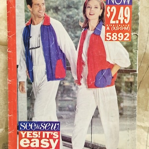 May include: A sewing pattern envelope for a jacket and pants set, labeled See & Sew Now 5892. The cover features two individuals wearing white outfits with color-blocked vests in red, blue, and white. The text reads See & Sew Now, 5892, and Yes! It's easy.
