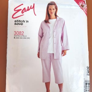 May include: A McCall's sewing pattern titled "Easy stitch 'n save" featuring a woman in a light purple pantsuit. The pattern number is 3082, with sizes B [26W-28W-30W-32W]. The cover has the word "Easy" in a cursive font.