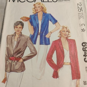 Può includere: Una copertina di cartamodello vintage con illustrazioni di donne in blazer marroni, blu e rossi. Il numero del modello è 6943 e la misura del busto è di 96,5 cm.