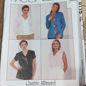 Puede incluir: Un patrón de costura que presenta cuatro estilos diferentes de blusas. La primera blusa es una blusa blanca de manga larga con cuello en V. La segunda blusa es una blusa azul de manga larga con cuello en V y un diseño geométrico colorido en la parte delantera. La tercera blusa es una blusa negra de manga corta con cuello en V y un pequeño diseño en la parte delantera. La cuarta blusa es una blusa rosa sin mangas con cuello en V y un cinturón blanco.