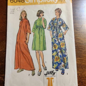 May include: A vintage Simplicity sewing pattern for a dress, with the pattern number 6048 and a price of $1.00. The pattern includes three different styles of dresses, one with a floral print, one with a green solid color, and one with orange polka dots. The pattern is labeled as "Jiffy" and "easy cut-easy sew".