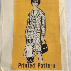 May include: Vintage sewing pattern featuring a woman wearing a floral print jacket and skirt with a matching handbag. The pattern is labeled "Printed Pattern".
